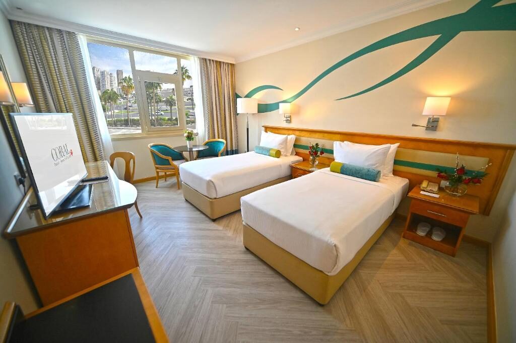 Twin room interior with sea-facing window at the resort