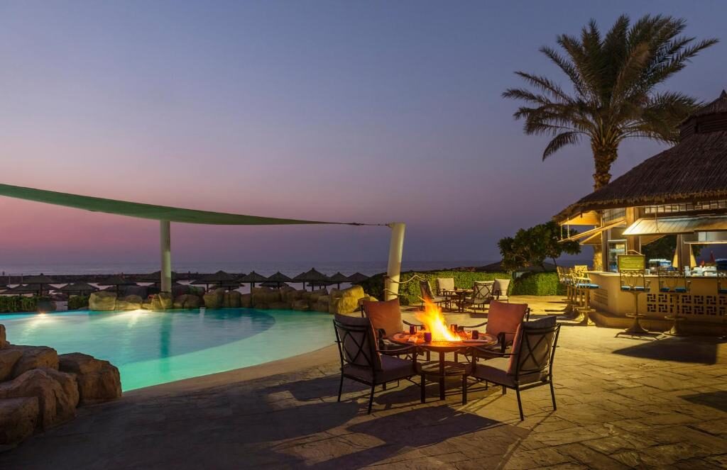 Pool terrace with fire table at dusk